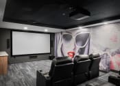 Thumbnail 22 of 53 - a screening room with black leather chairs and a large mural on the wall